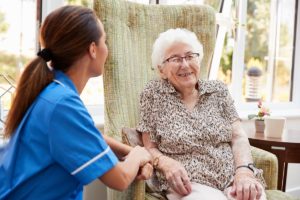 an elderly woman benefits greatly from professional care and support in an assisted living facility