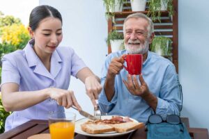 Nurse cuts food for seniors, as he and his family discover the benefits of respite care