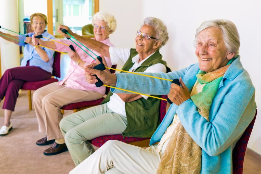 a group of seniors do some chair exercises