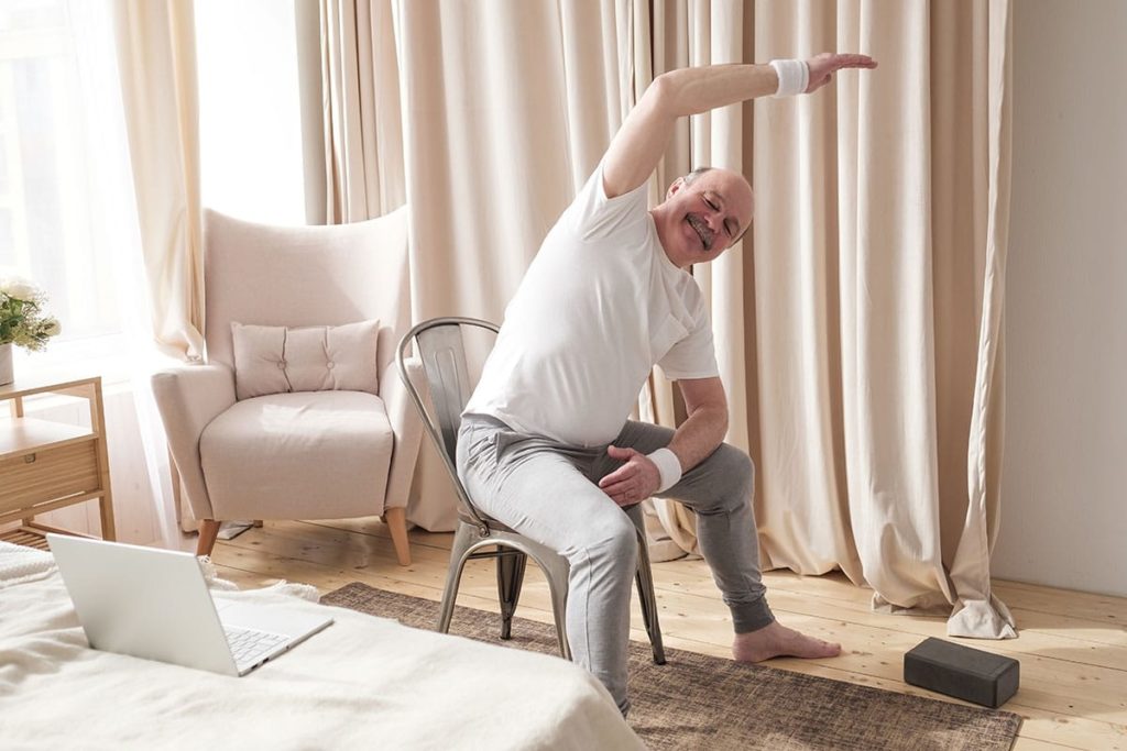 a healthy senior feels the benefits of a chair yoga regimen to support fitness and wellness