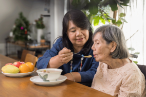 Respite caregiver feeds senior resident, one of her respite caregiver duties