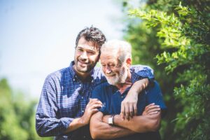 Man puts arm around his senior dad as he wonders how often he can use respite care