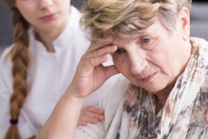 Senior puts head in hands as her daughter wonders, "how do I know if my parents need memory care?"