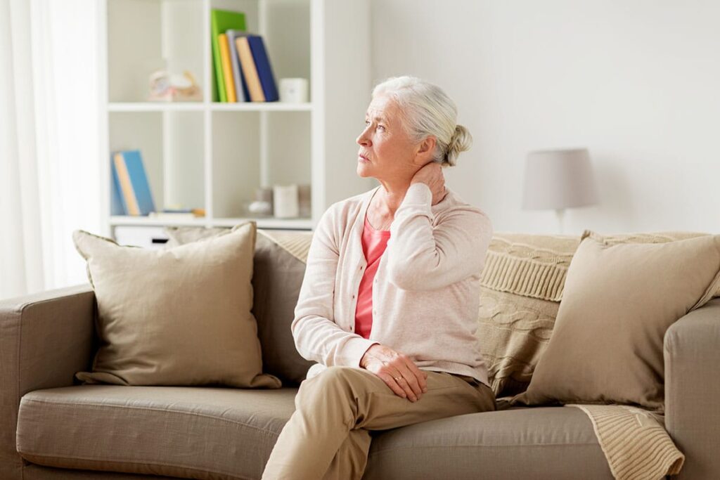 Senior sits on couch as she wonders what a memory bridge program is
