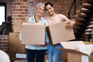 Woman helps senior mom pack as she prepares to enter independent senior living