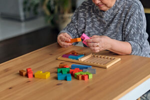 Senior resident looks at blocks during senior memory care