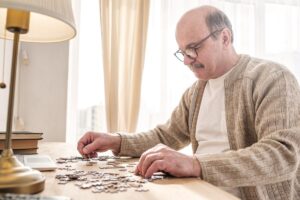 Man sits at table and struggles with puzzle while learning brain exercises for seniors