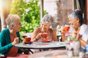 Senior talks with her friends over coffee about assisted living vs. home care