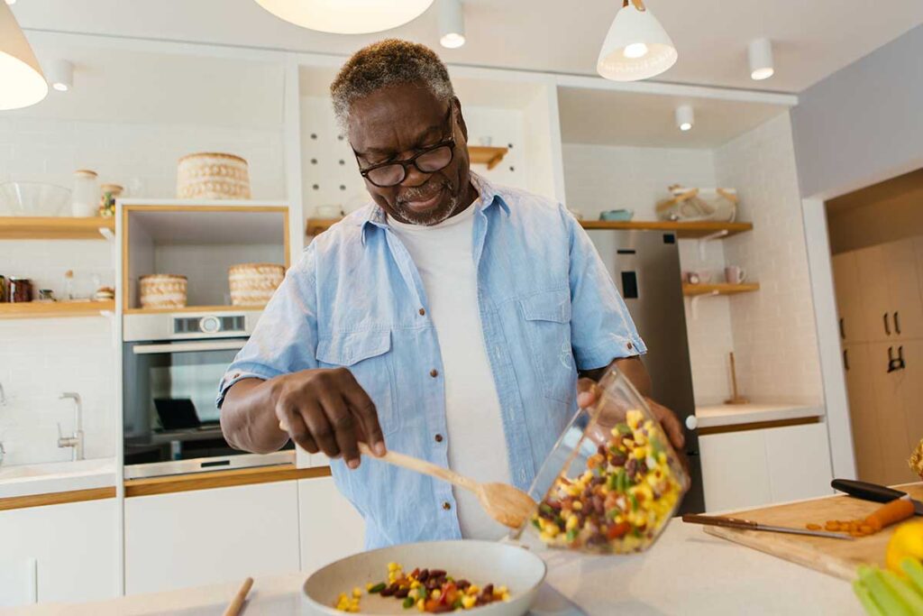 Senior cooks healthy meal after discovering nutrition counseling for seniors