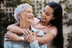 Woman puts arms around senior relative after learning about supporting seniors in assisted living