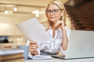 a person looks at a laptop and paper for Understanding Medicare and Health Insurance