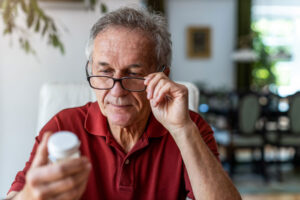 Man reads label on medication bottle after creating a medication management plan