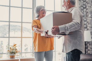 Senior passes box to husband after they discover tips for seniors to downsize